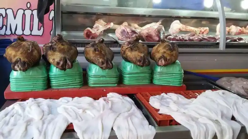 <p>Sıcaktan korunmak için kapalı alanları, gölgelikleri tercih ederken sehven Kasaplar Çarşısına çıktı…</p>
<p>Aman Allah’ım!</p>
<p>Her yanım kelle, karın, bumbar, ayak, ciğer, yürek dolu.</p>
<p>Kendi kendime <strong>‘iyi ki vejetaryen değilim’</strong> diye sevinirken pişmiş kellelerle göz göze geldim!</p>
<p>Biri sanki <strong>‘pışt’</strong> dedi! Ses uyumundan olsa gerek, hatırıma hemen <strong>Sait Faik Abasıyanık</strong>’ın <strong>“Hişt Hişt” </strong>hikayesi geldi!</p>
<p>Hemen ortama odaklandın. Gözüme bakıp duran pişmiş kelleye yanaşıp sohbete başladım:</p>
<p><strong>- Bana mı seslendin?</strong></p>
<p>- Evet evet, yaklaş!</p>
<p><strong>- Buyur!</strong></p>
<p>- Sırıtıp durduğuma bakma, dertliyim!</p>
<p><strong>- Hayırdır, ne derdin var?</strong></p>
<p>- Yediğim ateş neyse de bir de böyle insanlara film etmiyorlar mı, bu bana çok koyuyor!</p>
<p>***</p>
<p>Baktım, Kasaplar Çarşısı esnafıyla beni papaz edecek, ‘hoşça kal’ diyerek uzadım.</p>
<p>Ardımdan bu sefer <strong>‘hişt hişt’</strong> diye seslendi ama duymazdan geldim…</p>
<p>*</p>
<p><strong>Adana gezimiz sürecek…</strong></p>